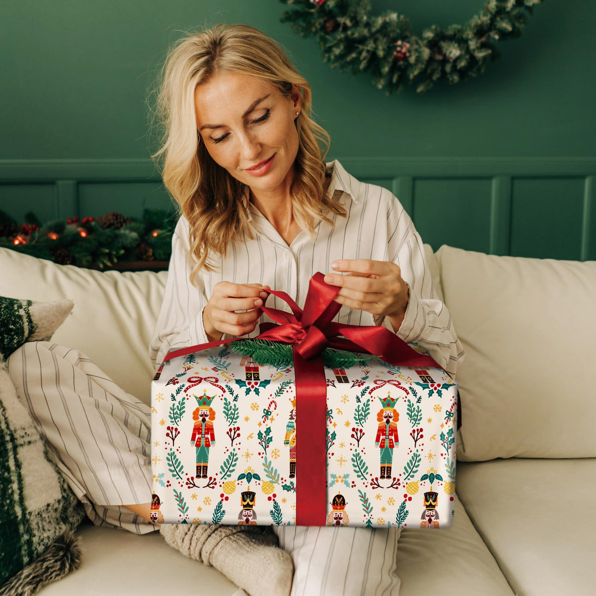 Nutcracker-themed wrapping paper with toy soldier pattern and red ribbon on a gift box.