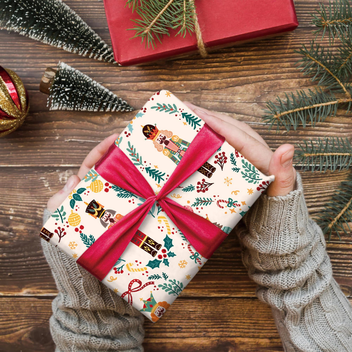 Nutcracker wrapping paper wrapped bundle with red ribbon bow and toy soldier motif.