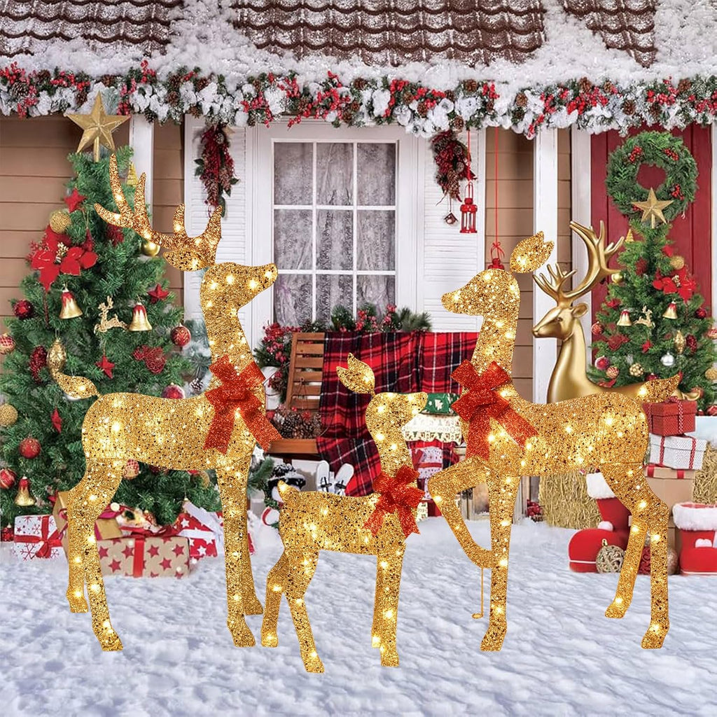 Gold glitter outdoor reindeer yard set with red bows glowing in snowy scene