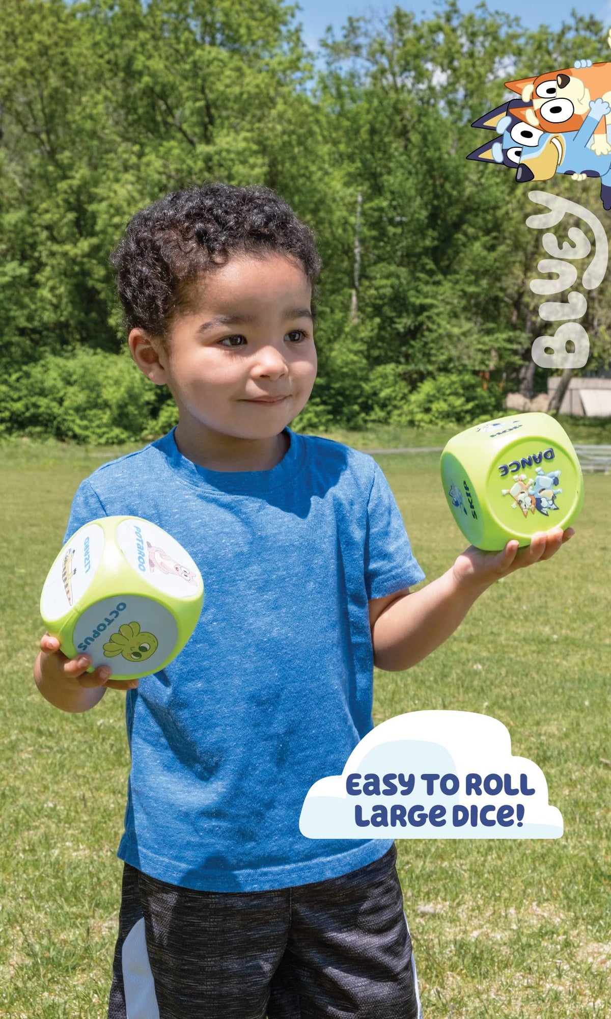 Kid holding large blue-and-green action dice for Bluey workout game outdoors.