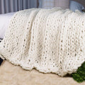Cream chunky knit throw blanket with thick chenille loop yarn texture, cable pattern