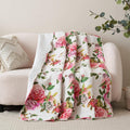 Quilted throw blanket with white base and pink rose floral pattern, scalloped edge look