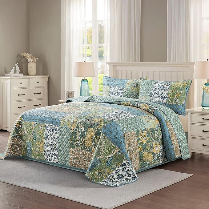 Twin-size bed with patchwork quilt bedspread and floral pillows in green and blue tones
