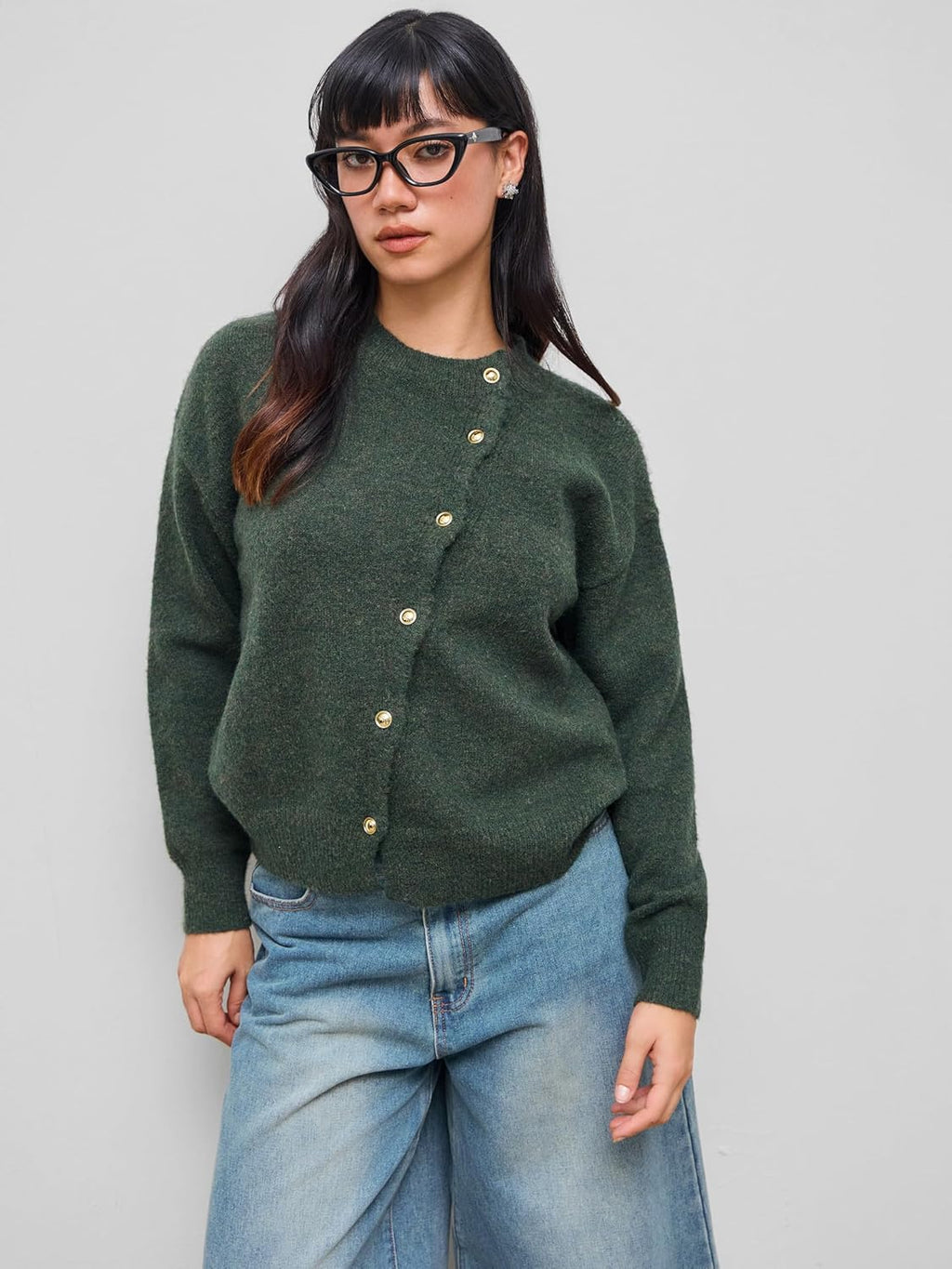 Dark green knit cardigan with crew neck and gold snap buttons, worn with light blue jeans