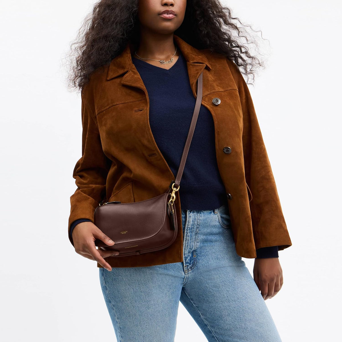 Brown leather crossbody hobo bag with detachable chain strap and magnetic closure.