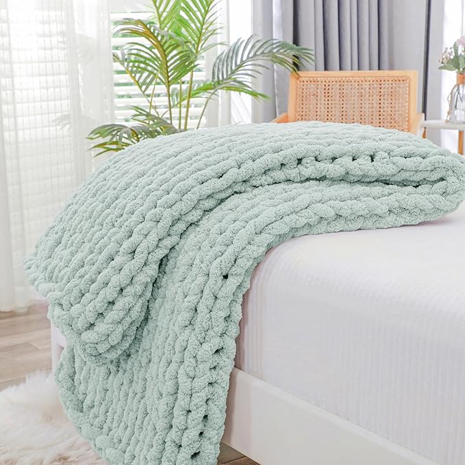 Mint chunky knit throw blanket with raised rope-knot cable texture, draped on couch.
