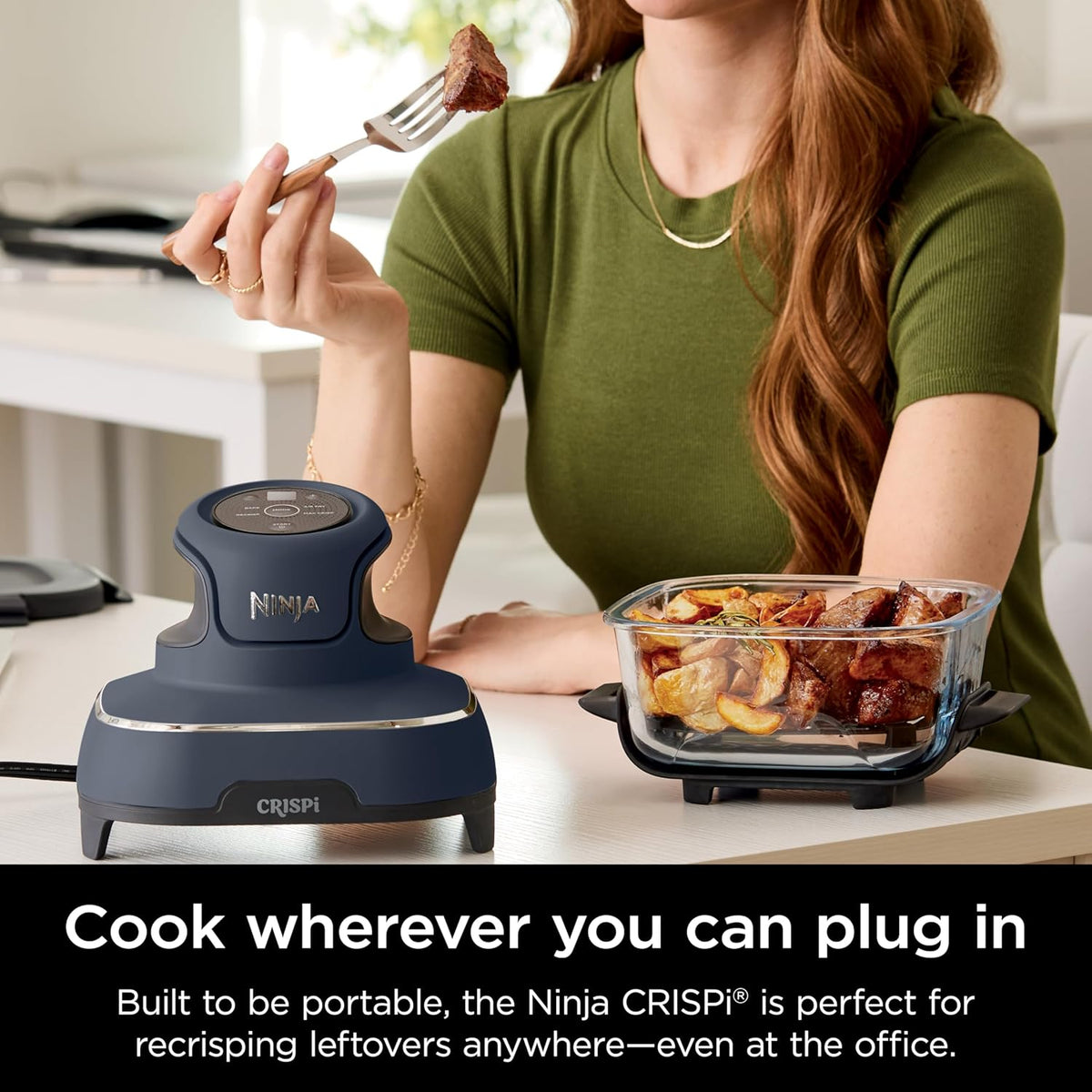 Portable air fryer with gray base and clear glass cooking container holding assorted food