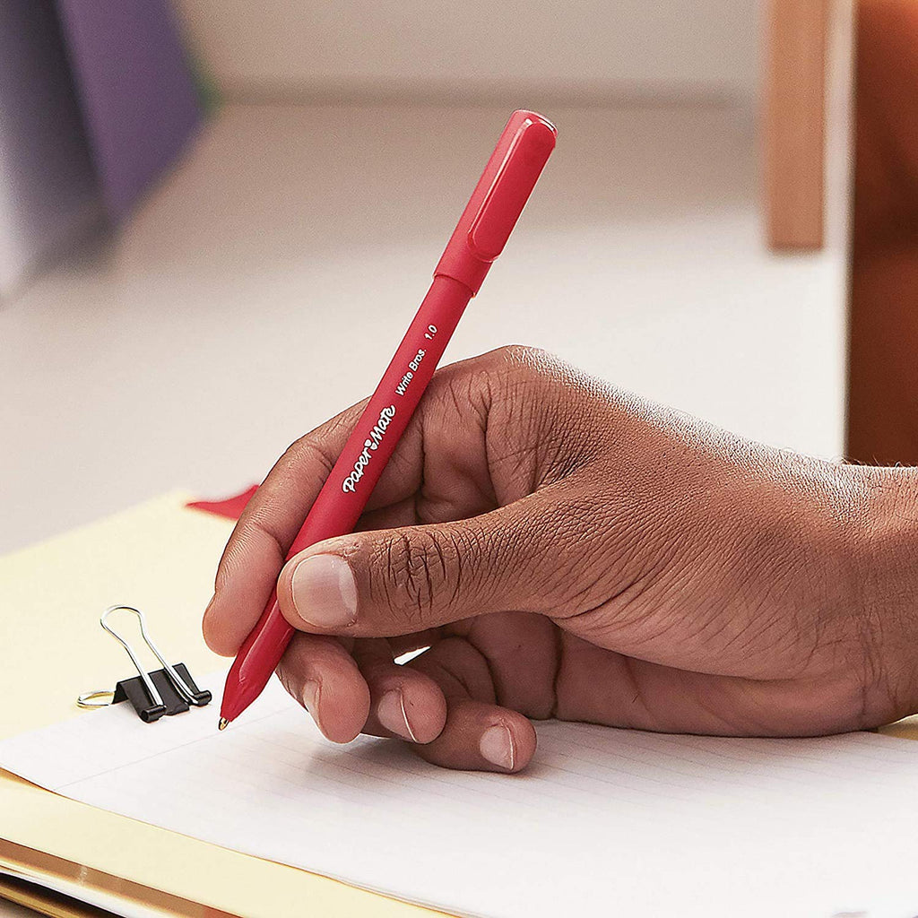 Hand holding a ballpoint pen over paper