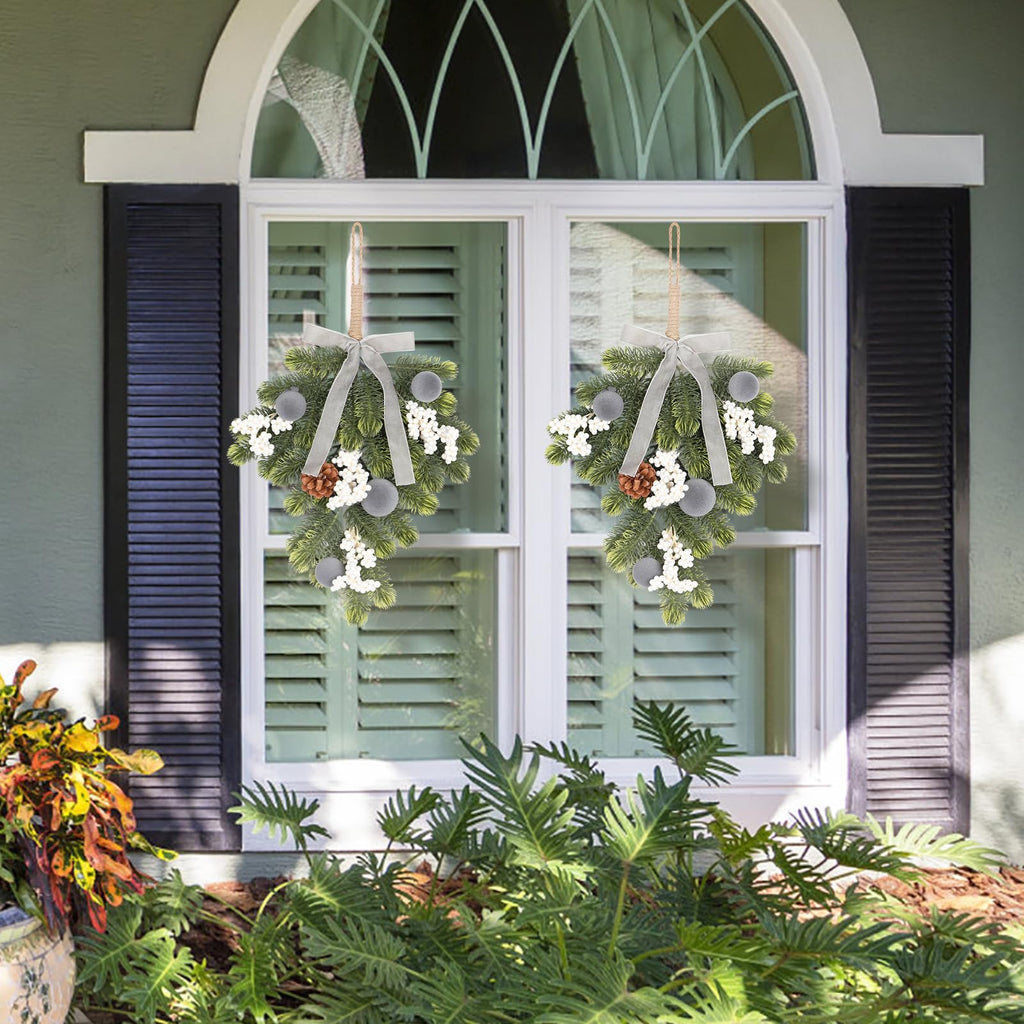 Artificial green wreaths with gray ribbon bows, pine cone accents, and silver ball decorations