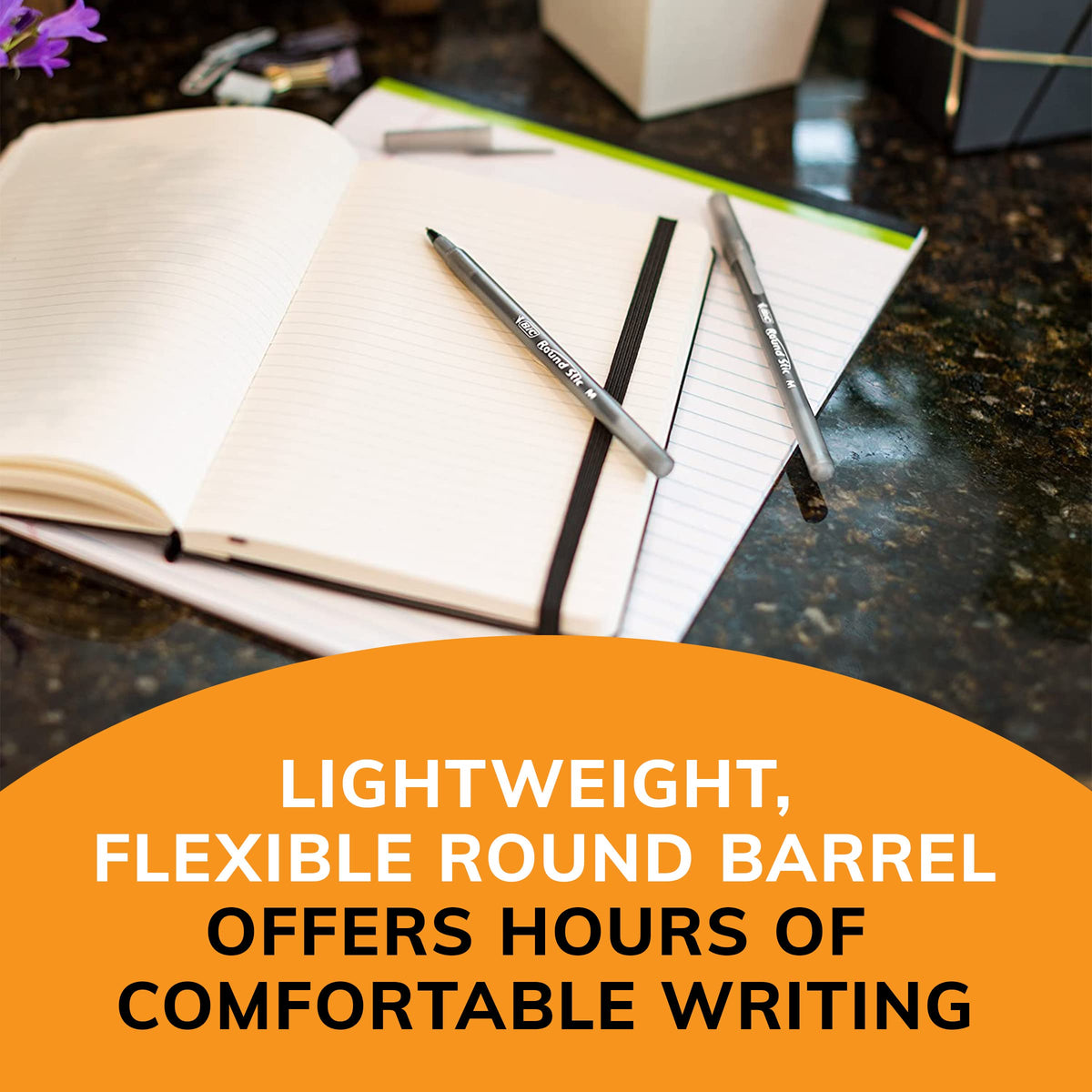 Black ballpoint pens with slim round barrels on open notebook page.