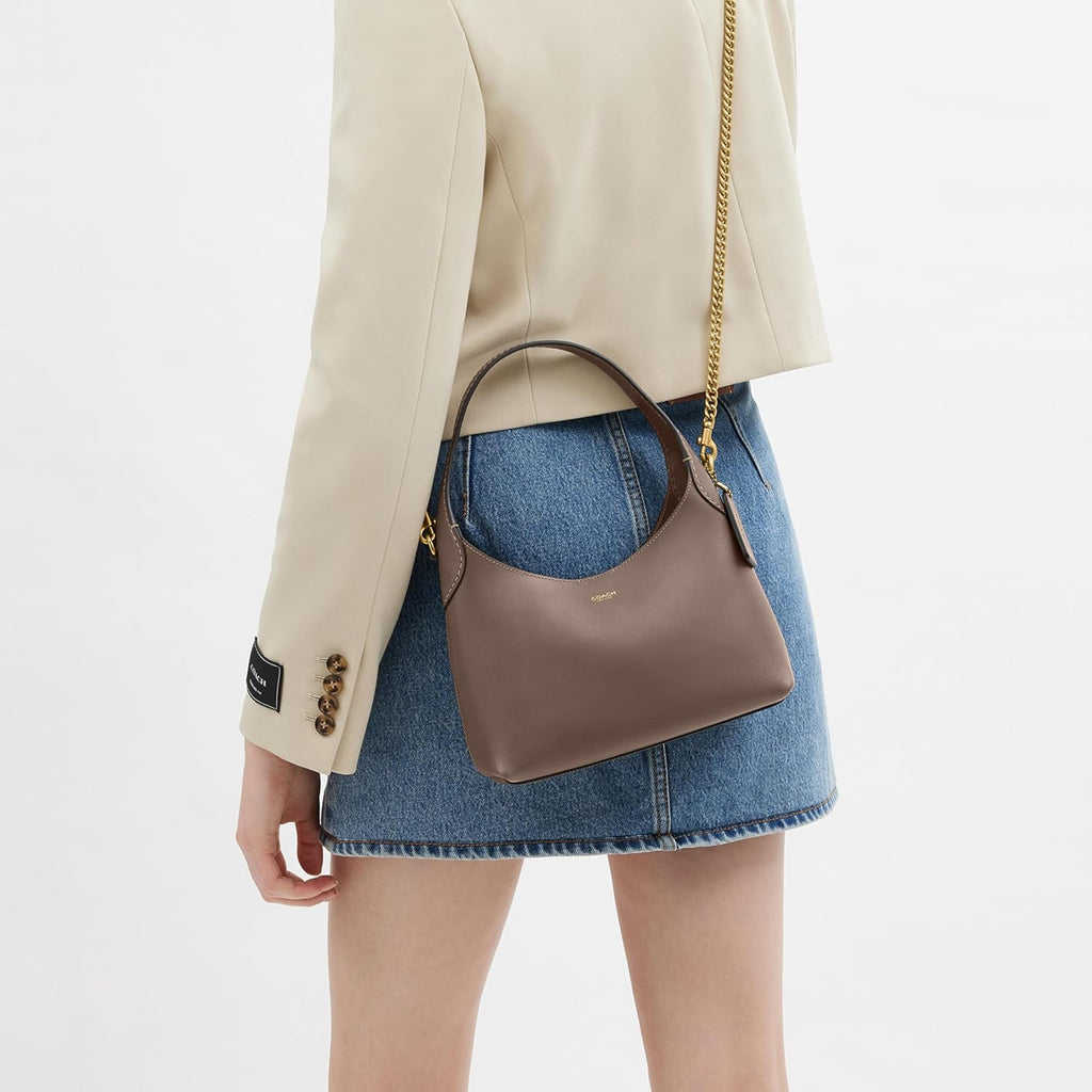 Hobo bag on shoulder with chain strap, worn over denim skirt