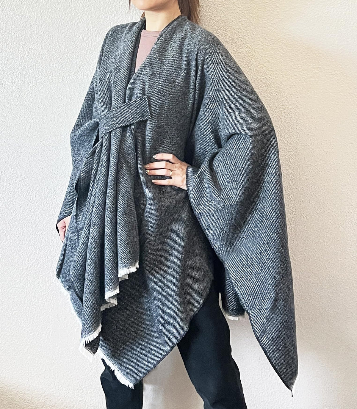 Women’s dark blue-grey fringe poncho shawl with open front and wrap-tie detail, draped cape.