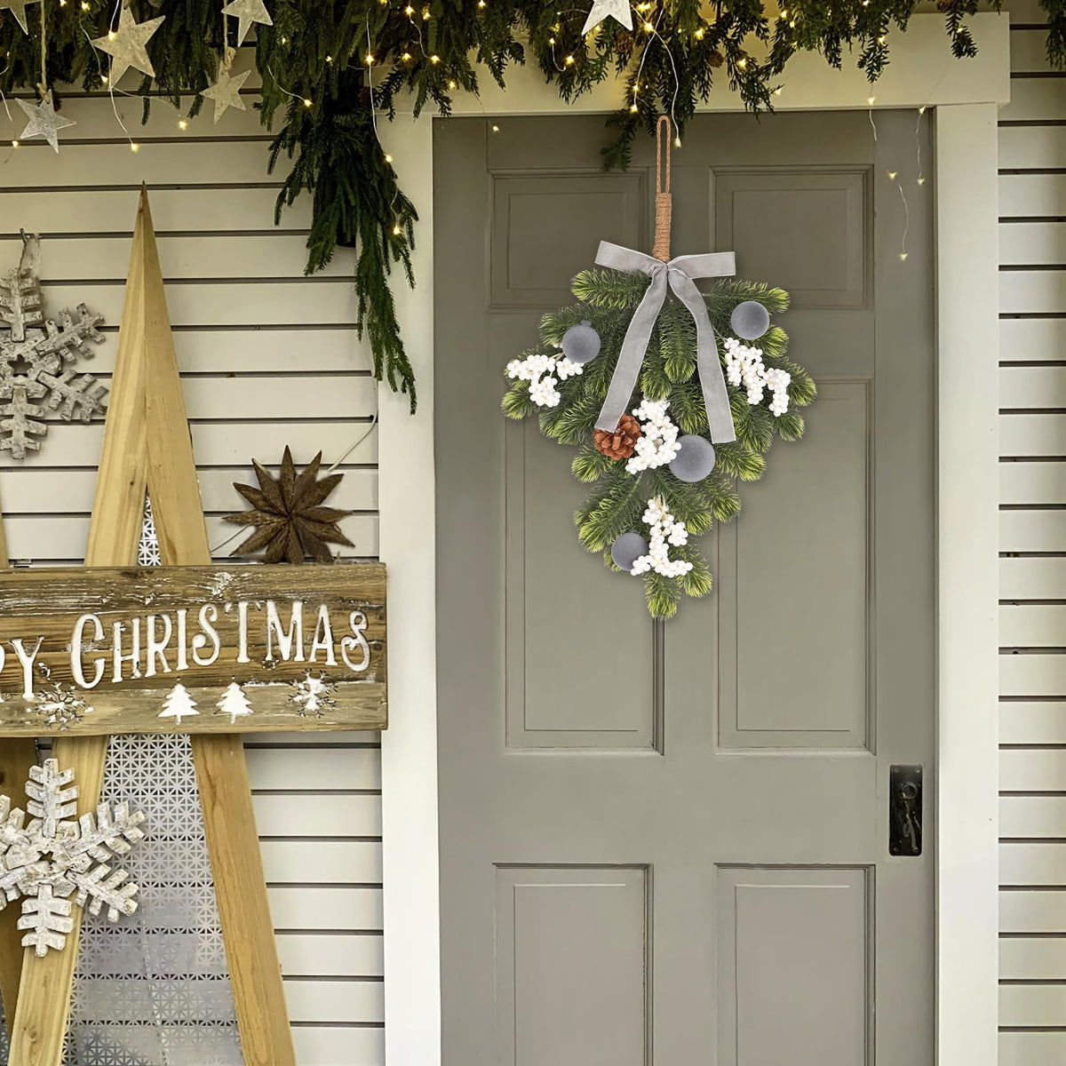 Hanging green wreath with gray ribbon bow, pine cone accents, and silver ball ornaments