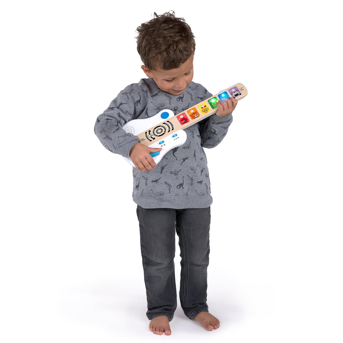 Light-up wooden guitar toy with colorful animal keys, held by a child in full view