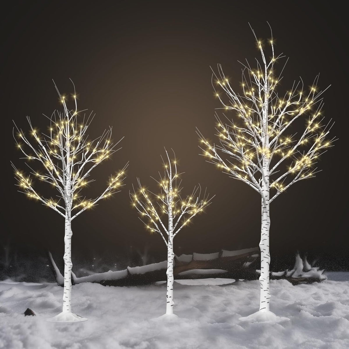Three white birch tree light decorations with warm white LEDs in snowy yard