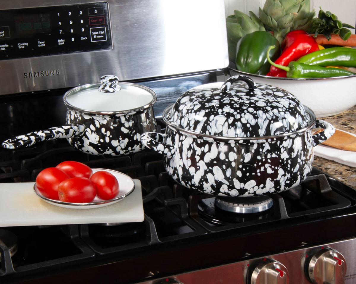 Black speckled 4-quart enamel Dutch oven with domed lid on a gas stovetop