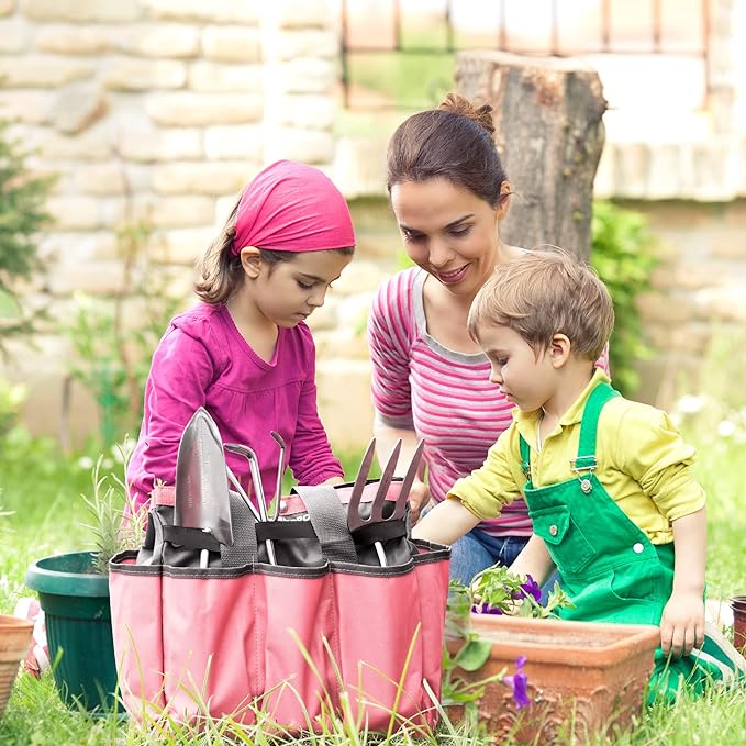 Pink garden tool tote bag held outdoors with tools visible in front pockets