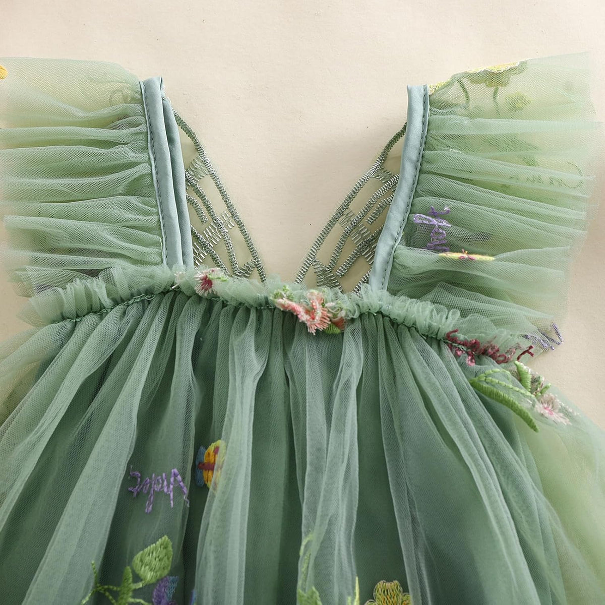 Green mesh sleeveless romper top with V-back straps and butterfly wing trim