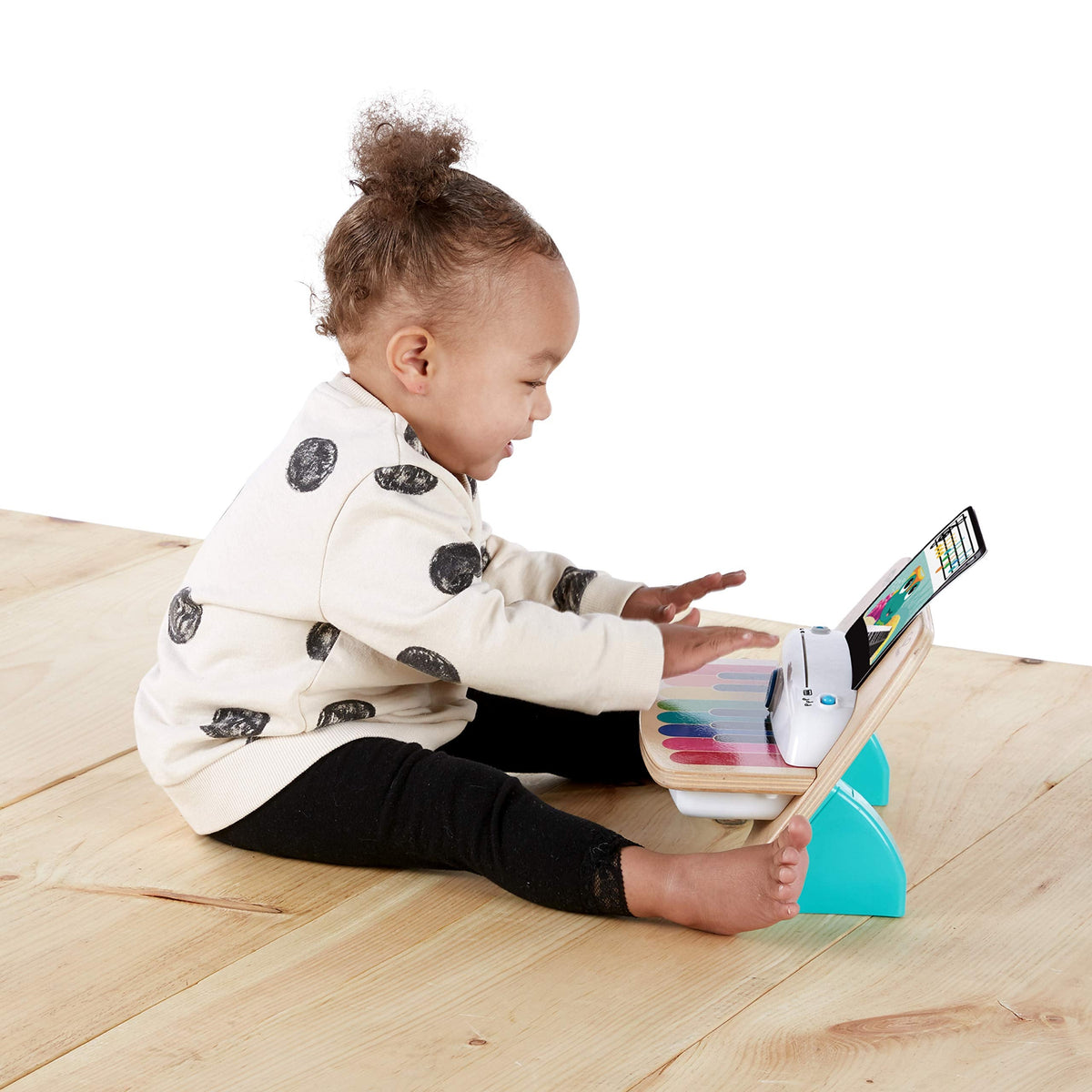 Baby playing wooden music piano with colorful tablet screen and keys