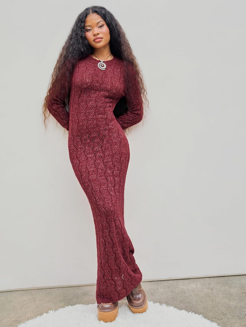 Burgundy long-sleeve crewneck maxi sweater dress with textured knit, fitted design.