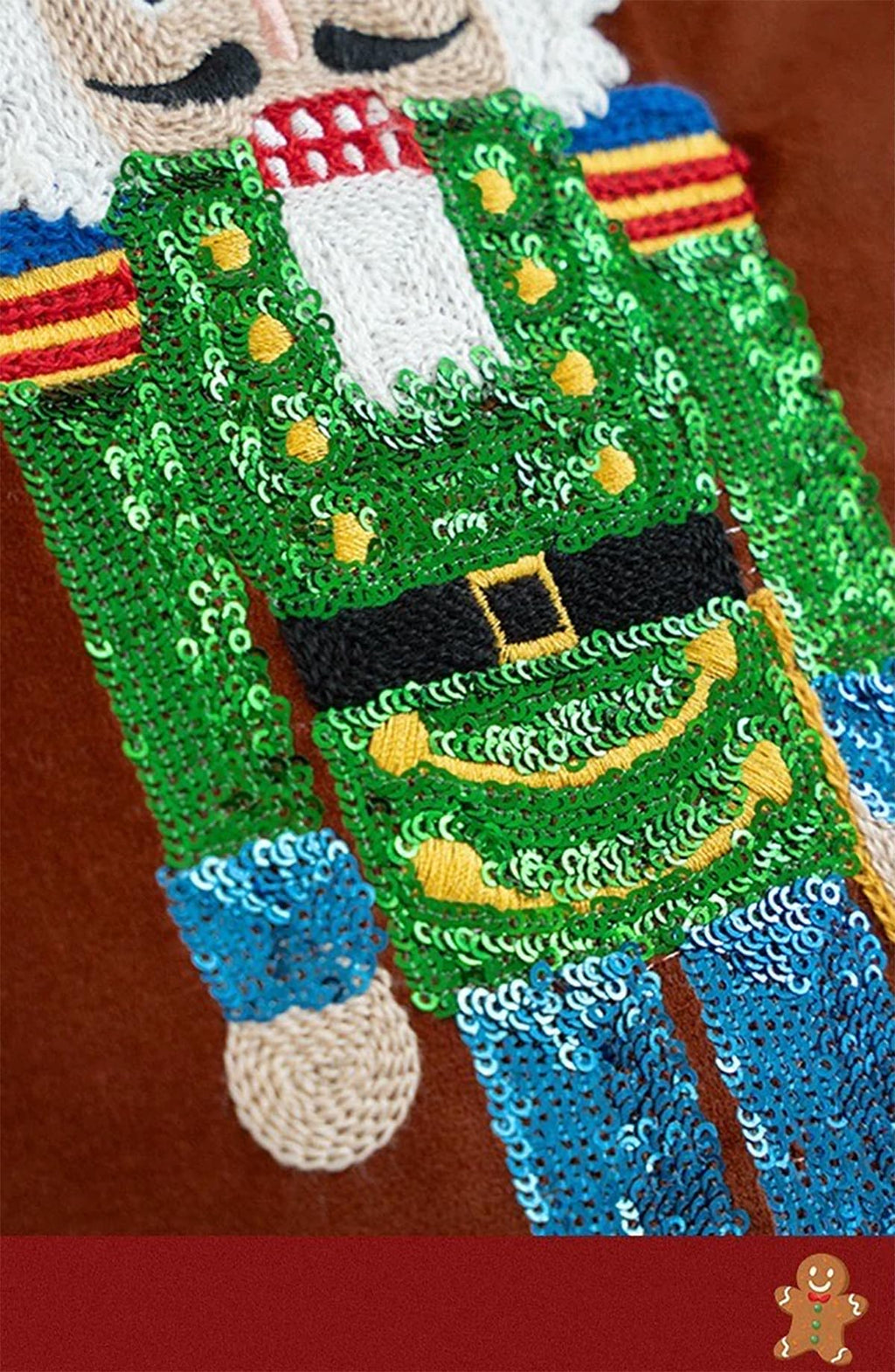 Sequin nutcracker embroidery on green pillow cover panel with colorful striped clothing