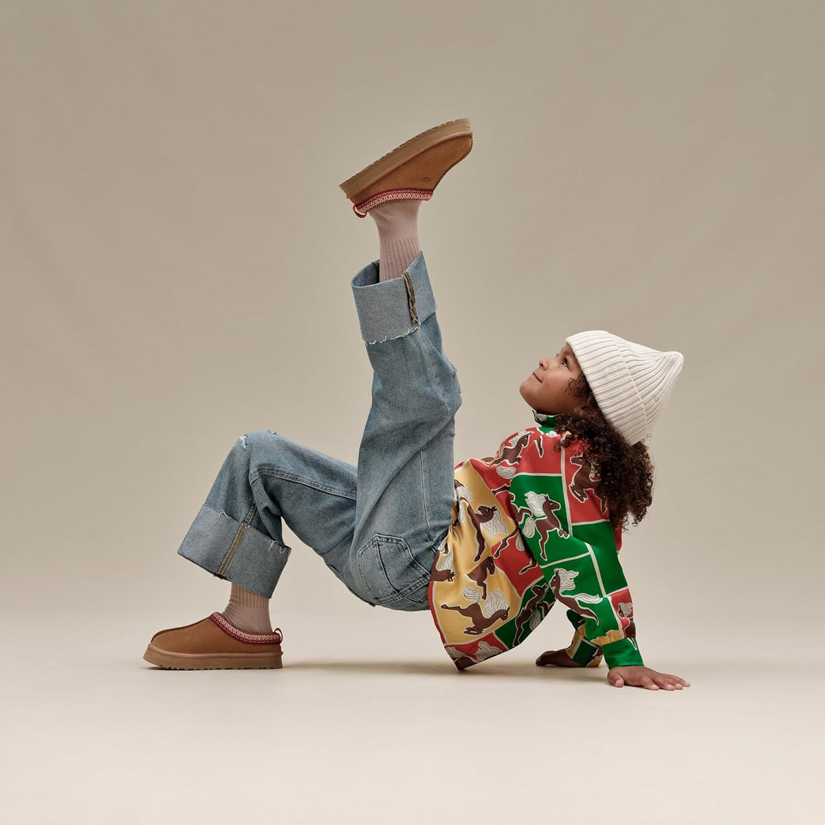 Kids' Tazz chestnut suede slipper shown worn, with red knit collar and grippy sole