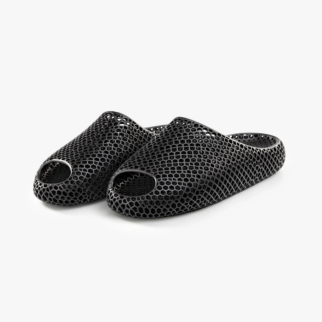 Black 3D-printed mesh slippers, angled view showing multiple toe openings.