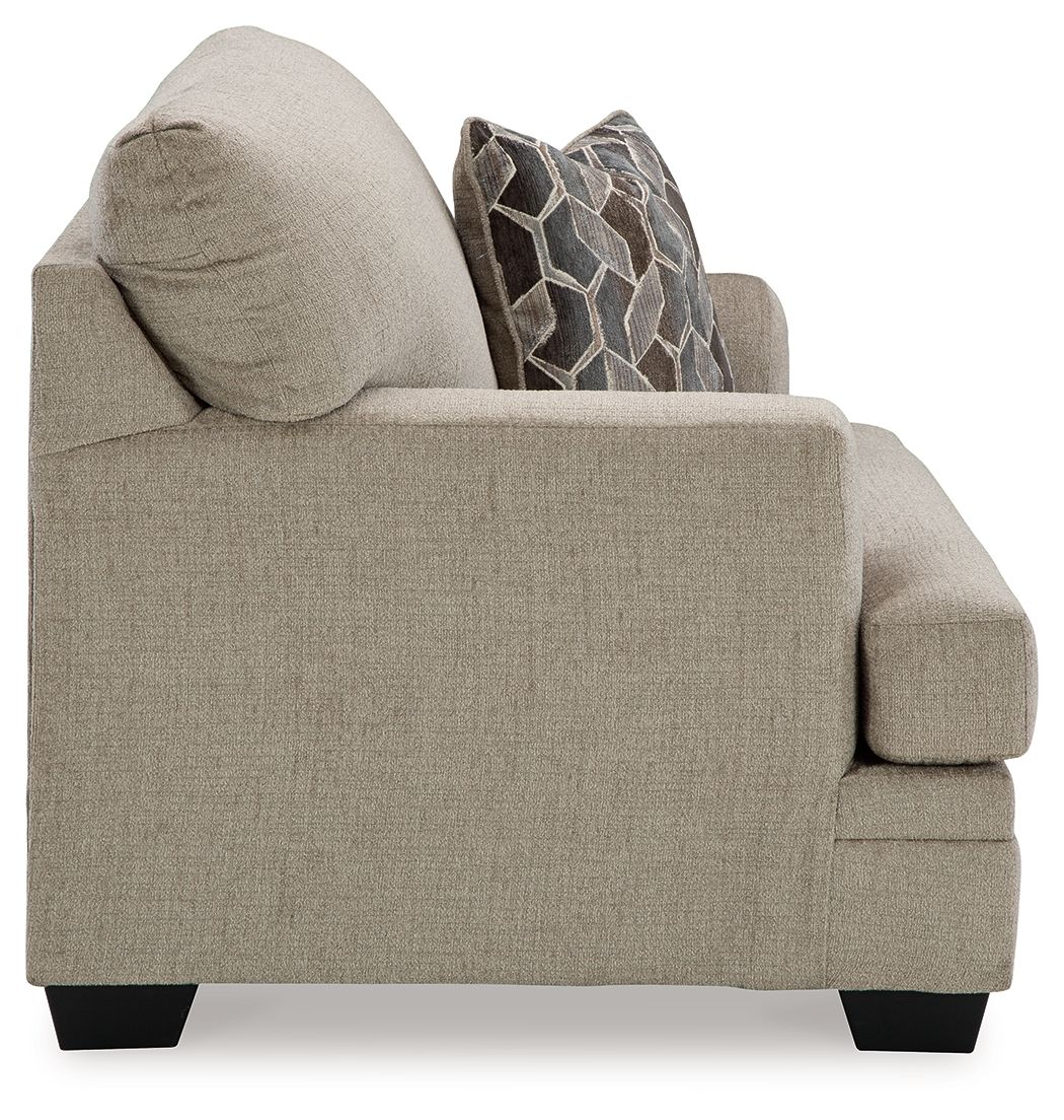 Upholstered sofa chair with rounded arm, light gray-brown fabric and decorative throw pillows