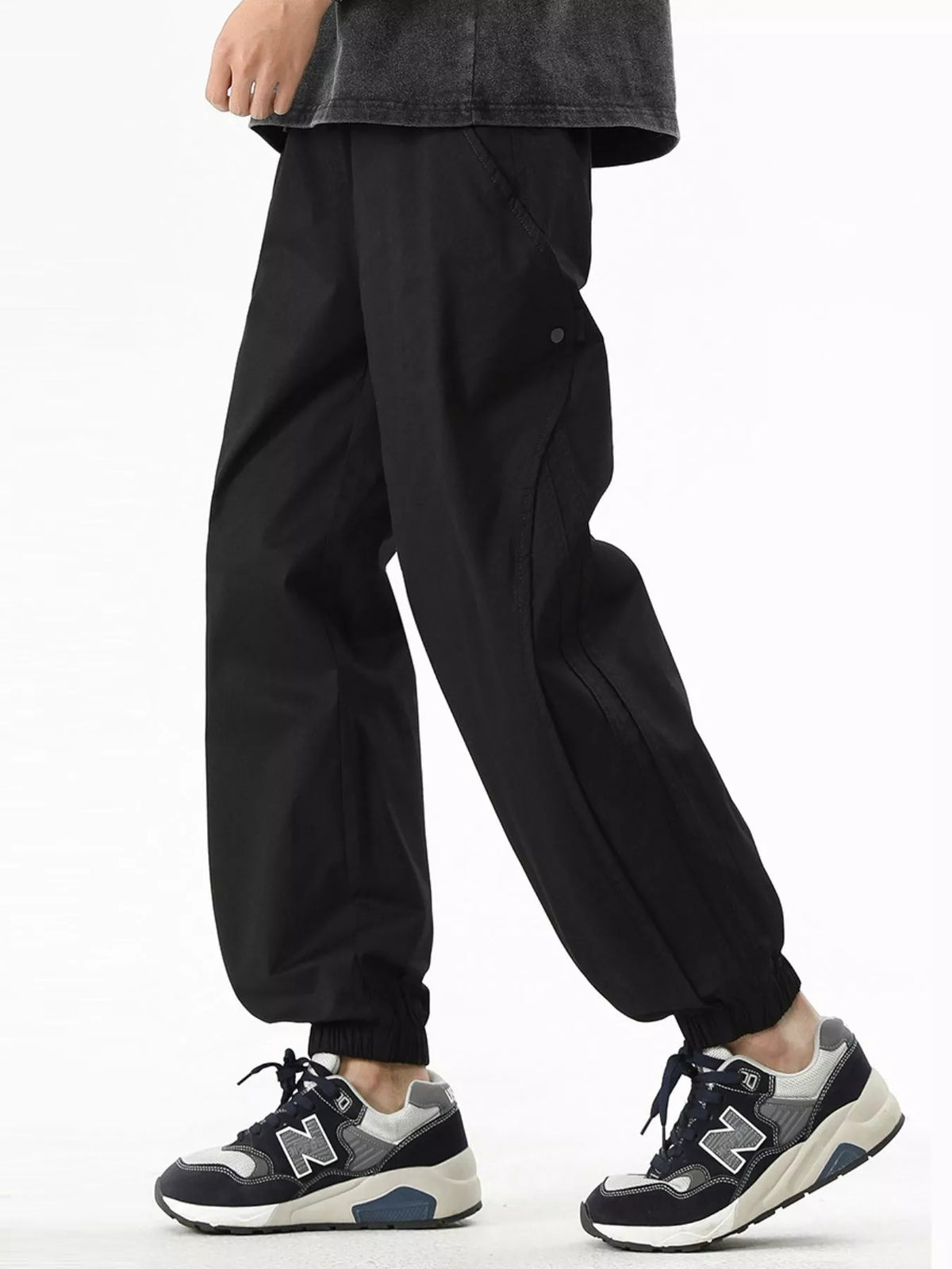 Black loose-fit drawstring casual pants with side button detail, elastic waistband and ankle cuffs