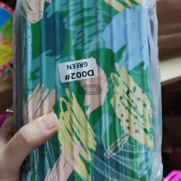 Cosmetic bag with green, blue, and cream jungle-leaf pattern, sealed.
