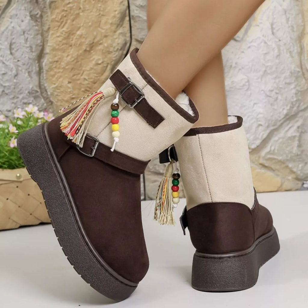 Two-tone ankle boots with white uppers, brown sides, tassel charms, and buckles.