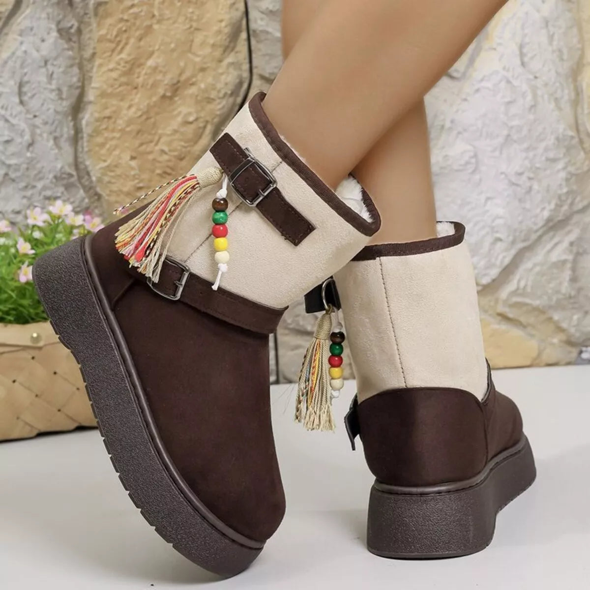 Two-tone ankle boots with white uppers, brown sides, tassel charms, and buckles.