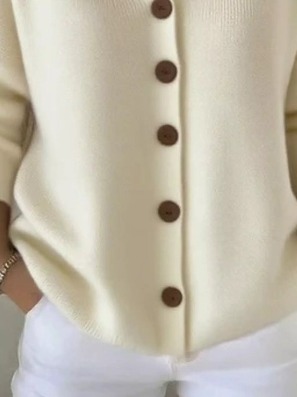 Beige hooded knit cardigan close-up of button-front and vertical seam