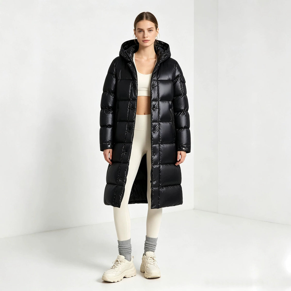 Black long padded hooded coat with front zipper and quilted stitch lines, over-the-knee