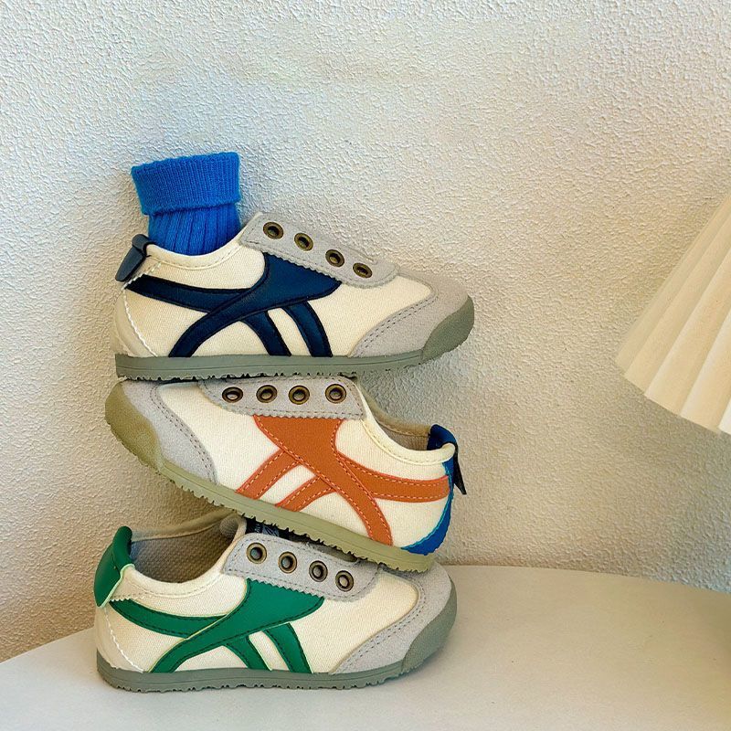 Kids casual sneakers with white uppers, orange and green side stripes, and blue collar trim.