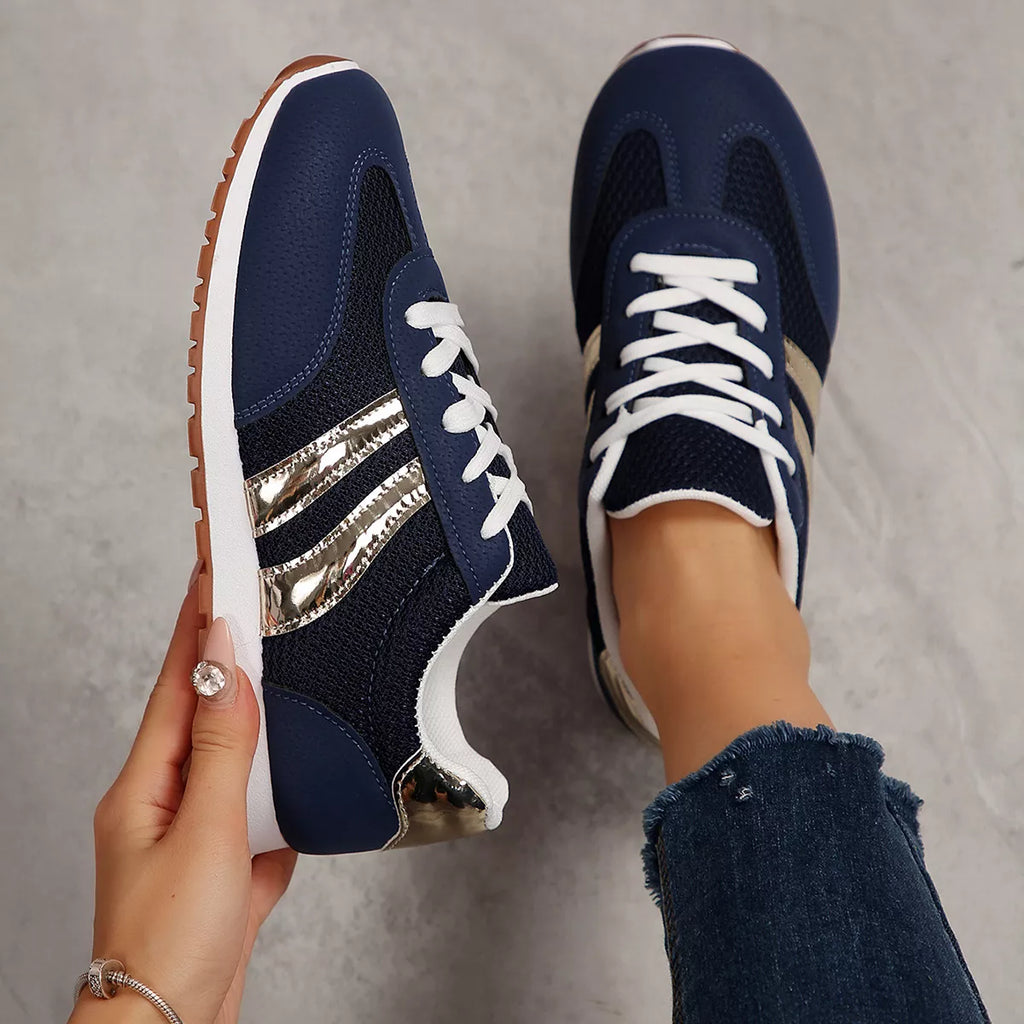 Pair of blue lace-up round toe sneakers with gold stripes and white laces