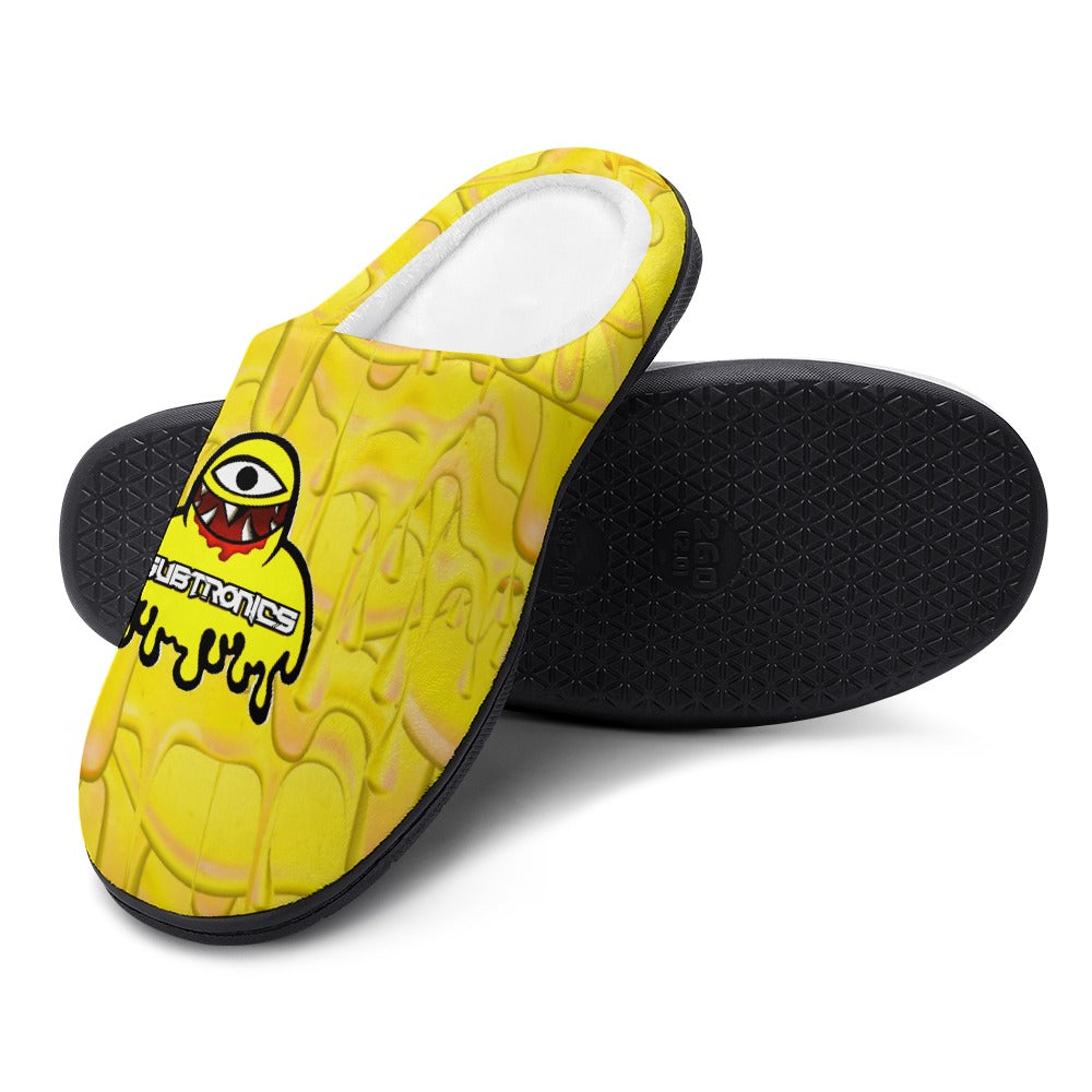 Yellow cotton slip-on slippers with black textured sole and graphic logo on upper.
