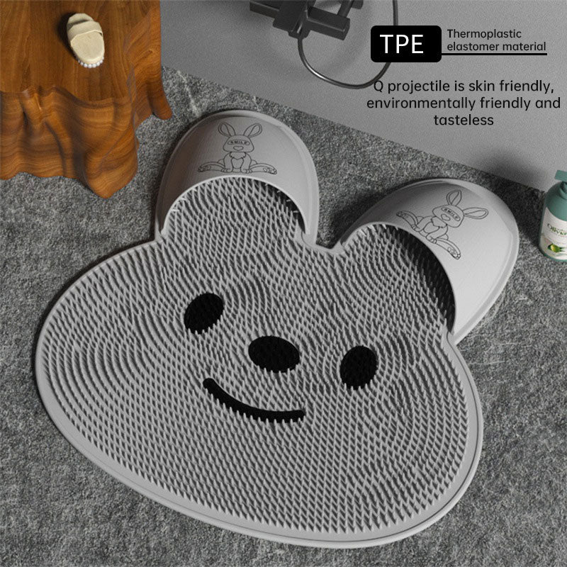 Gray silicone rabbit foot massage mat with raised texture and cartoon face