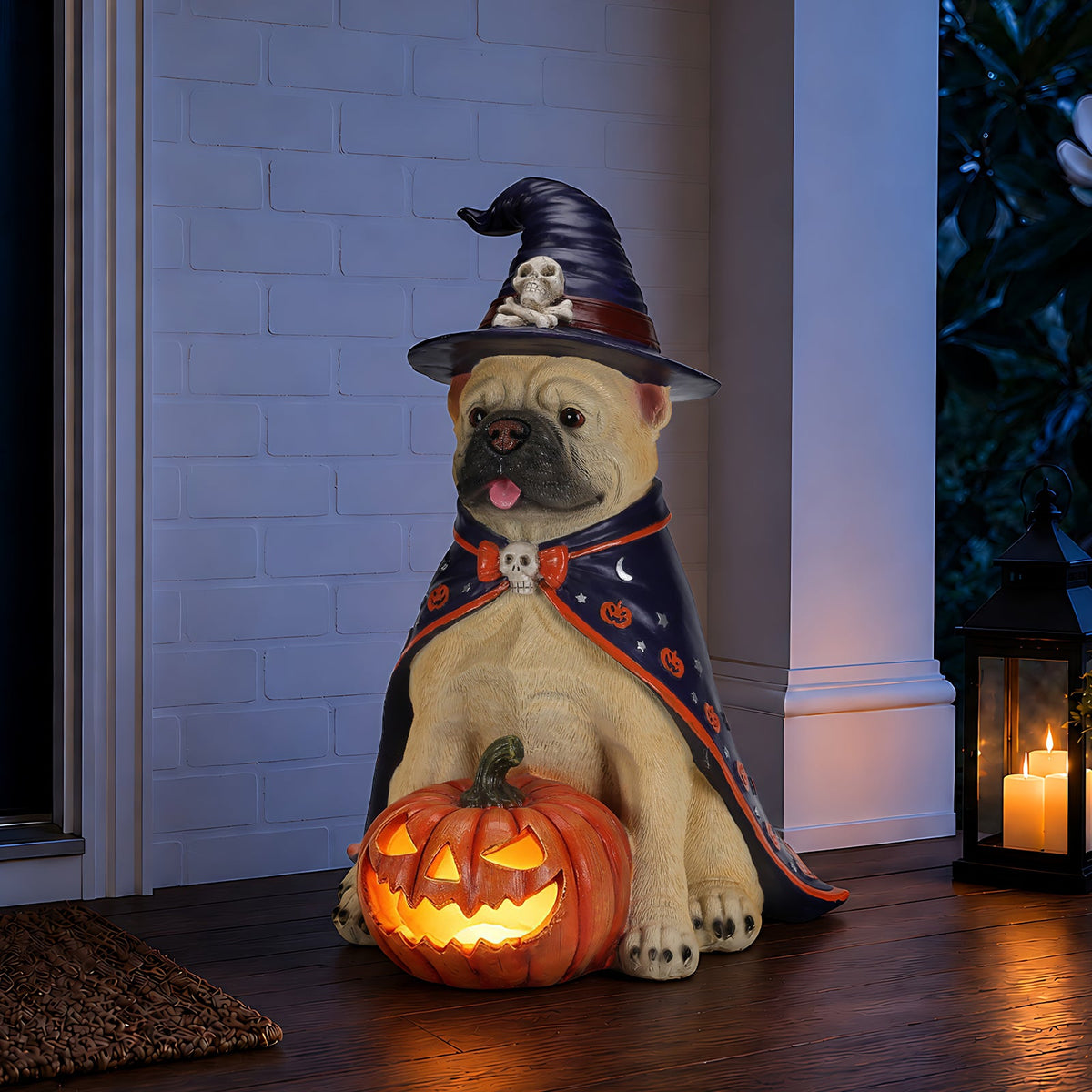 Sitting bulldog witch figurine holding a glowing orange jack-o-lantern