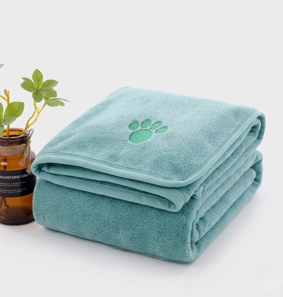 Quick-dry towel, light blue folded stack with green paw-print emblem