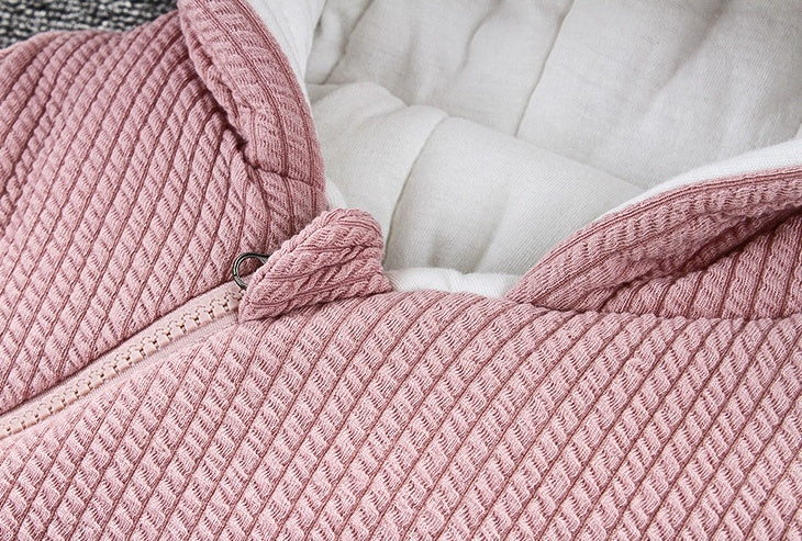 Pink textured snowsuit with front zipper and gathered hood trim