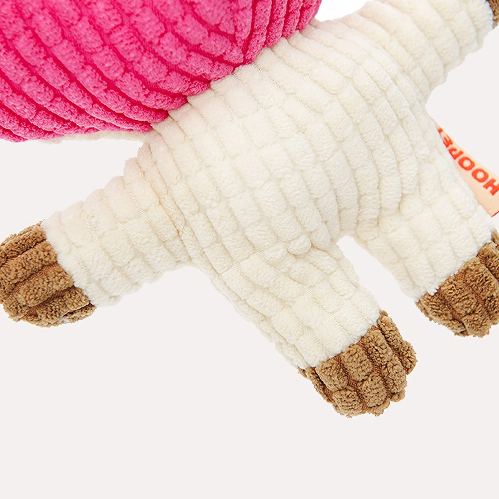 White and pink plush dog toy close-up with textured fabric