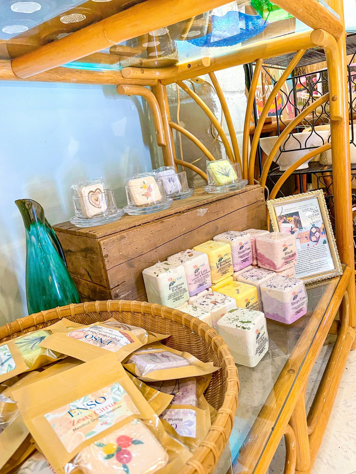 Bath bomb boxes on a wooden display shelf, stacked square cubes in bags