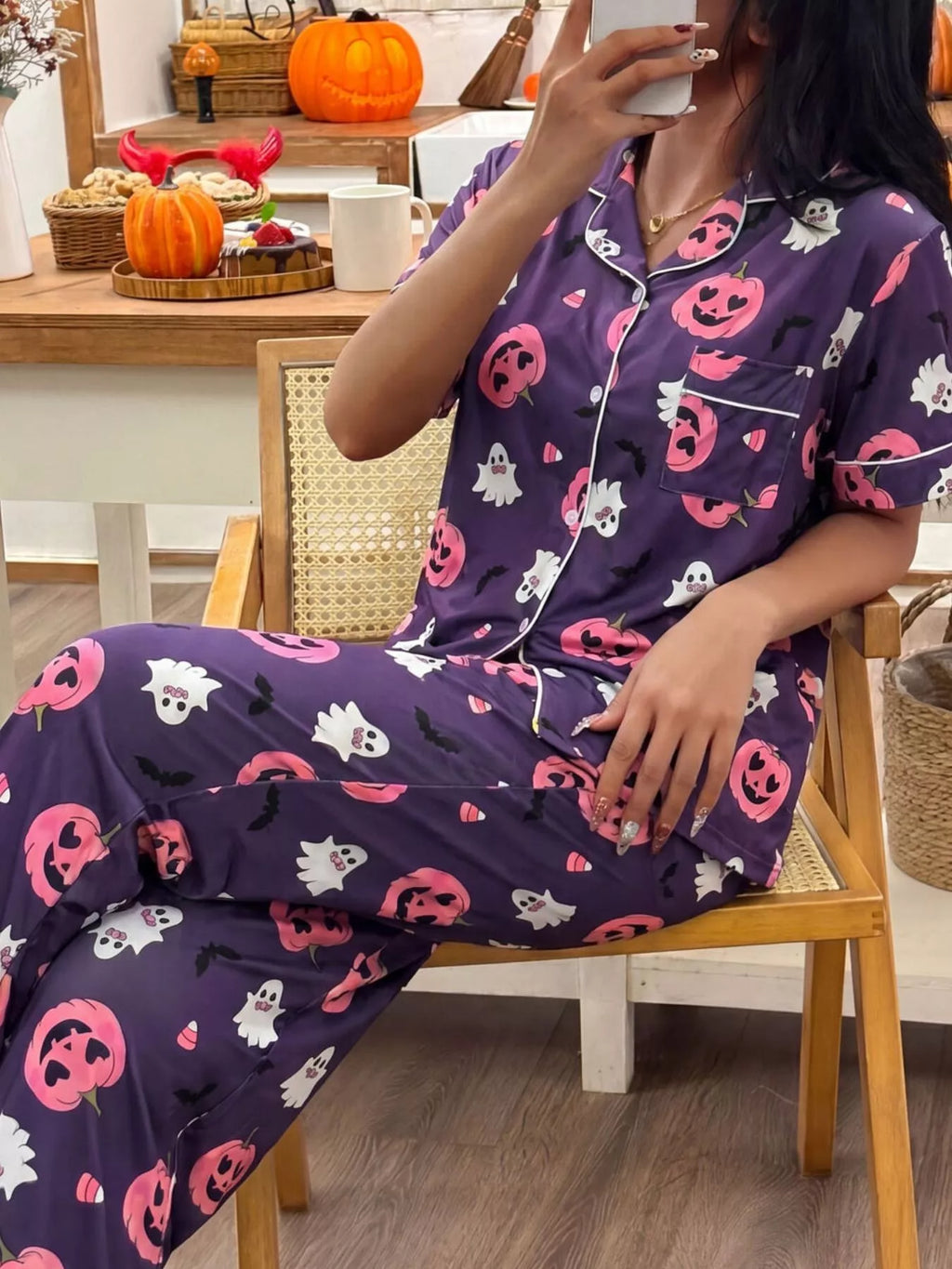 Purple pajama set with pumpkin, ghost, and bat prints, short-sleeve button-front top and matching pants