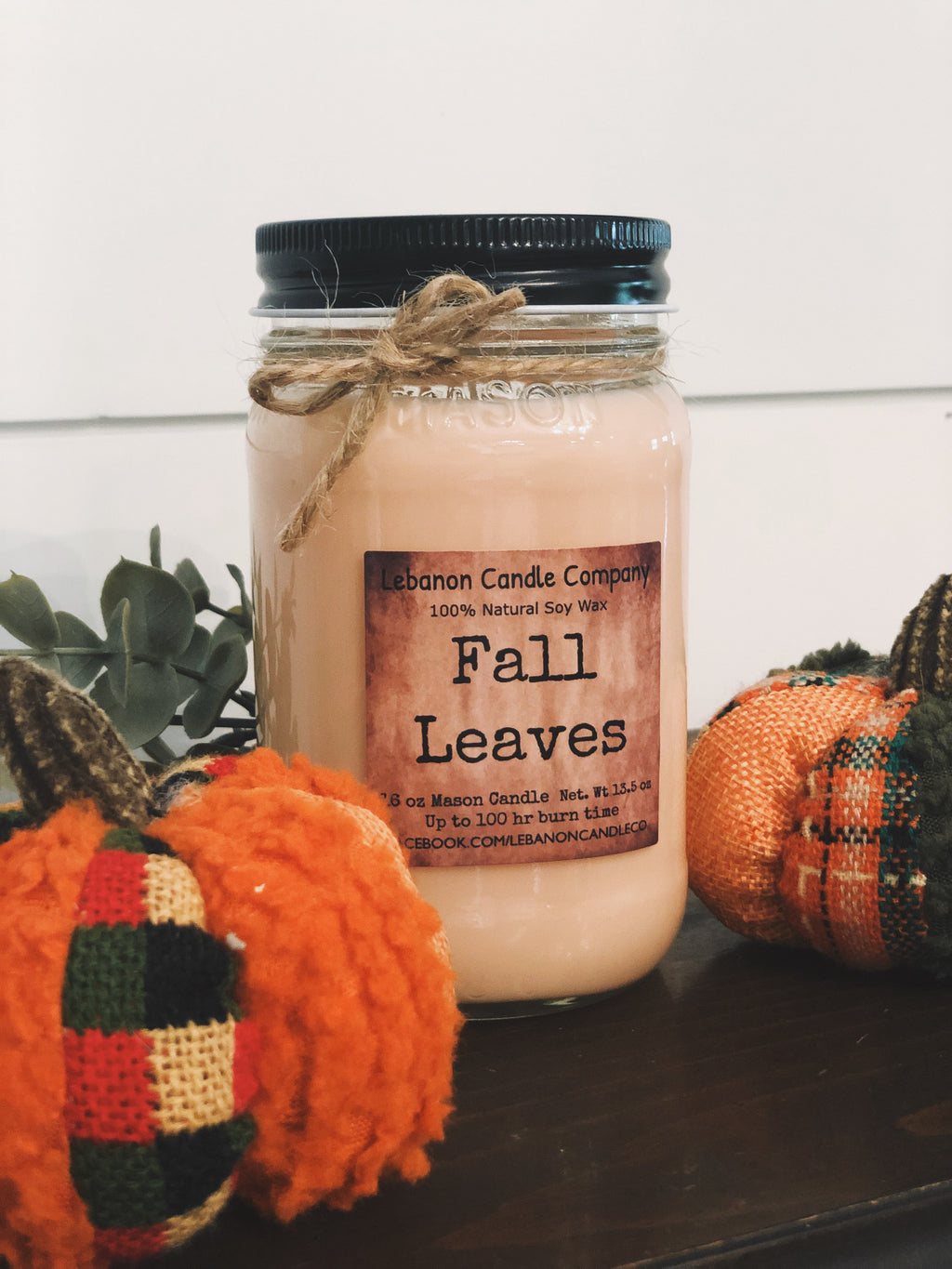 Amber jar candle with dark lid and twine wrap, “Fall Leaves” label on jar