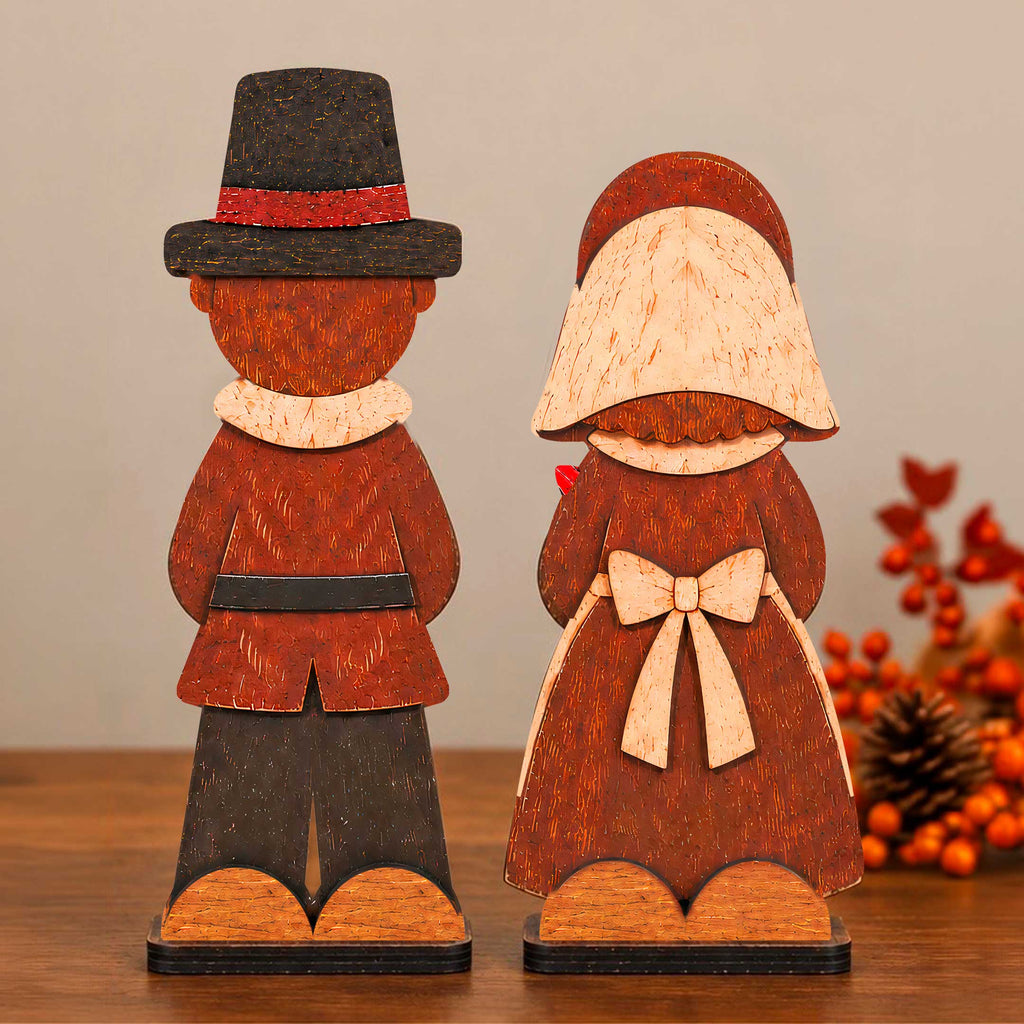 Wooden pilgrim couple tabletop decorations in dark brown and orange with hats and bows