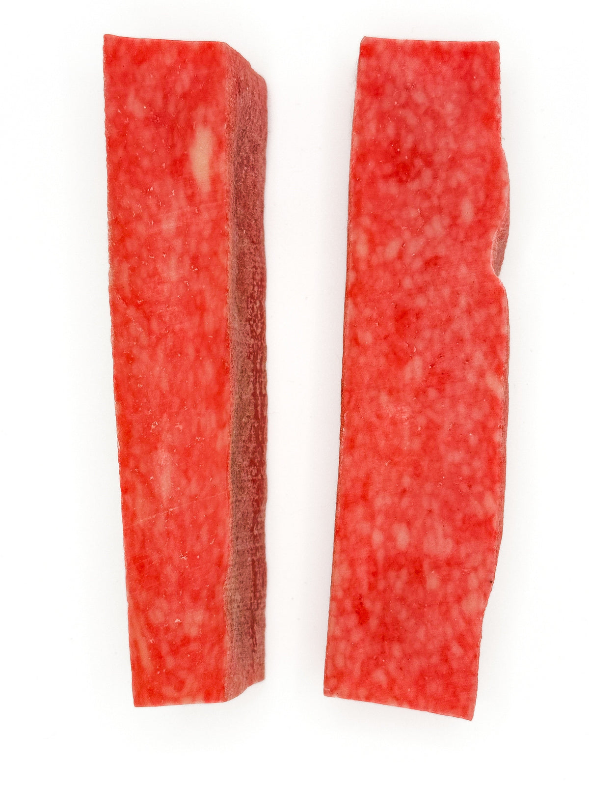 Two red yak cheese chew strips, textured surface