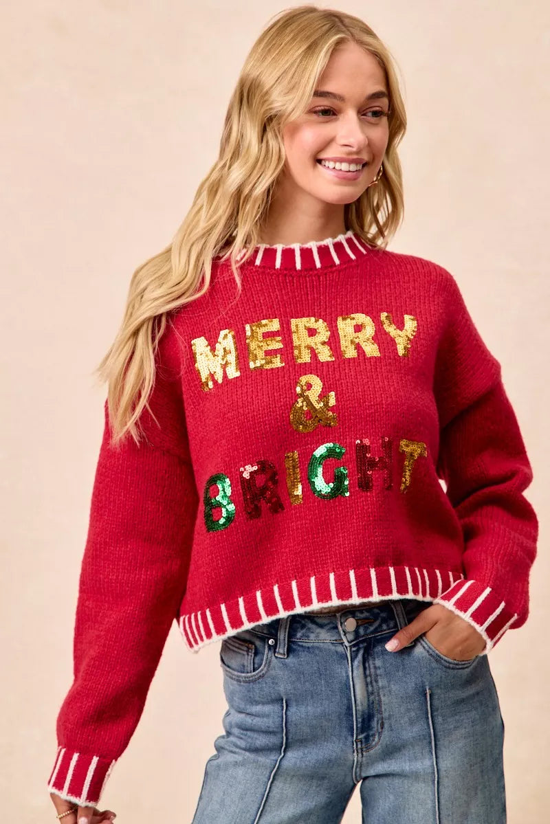 Red sequin knit sweater reading “MERRY & BRIGHT” with ribbed cuffs and hem trim