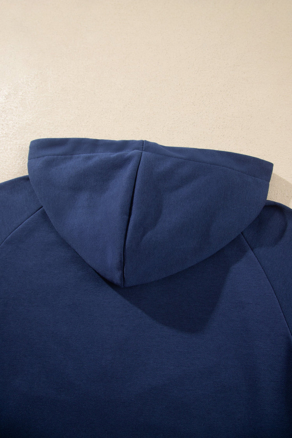 Navy hooded zip-up top back view with adjustable hood seam detail