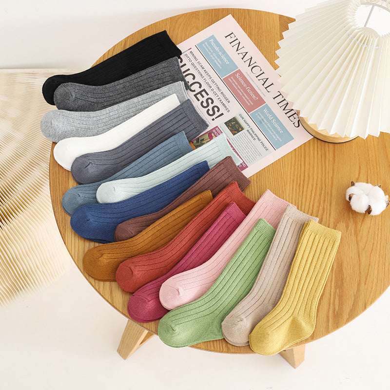 Assorted mid-calf ribbed baby socks in mixed colors, laid out together.